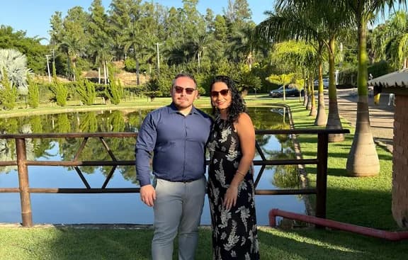Pollyana e Wayter em um jardim à beira do lago